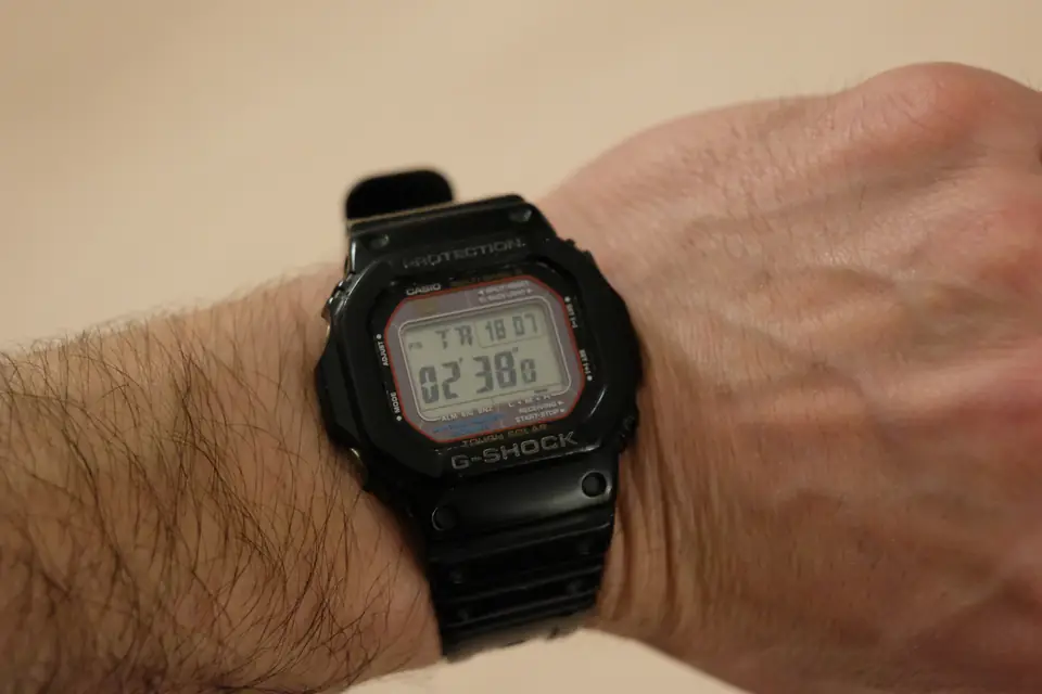 Montre de sport noire portée au poignet